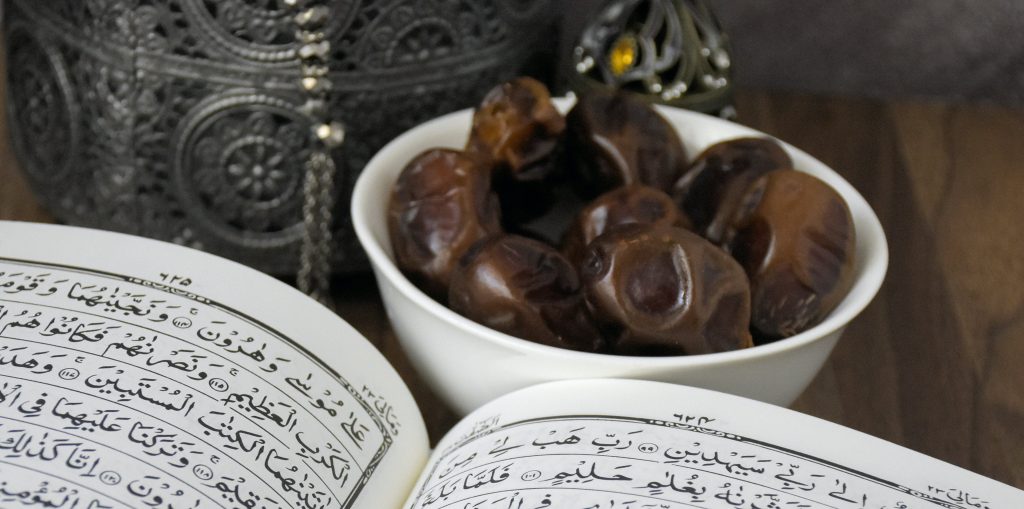 Dates in white bowl with open book