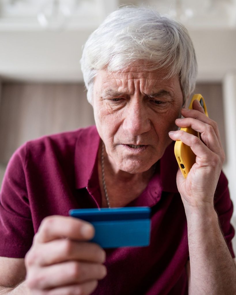 Person on a cellphone looking at a credit card