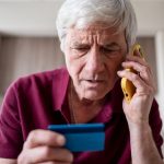 Person on a cellphone looking at a credit card